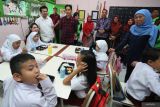 Wakil Presiden terpilih Gibran Rakabuming Raka (keenam kiri) didampingi Wali Kota Surabaya Eri Cahyadi (keempat kanan), Katua Umum PP Muslimat NU Khofifah Indar Parawansa (kanan), Ketua DPD Partai Demokrat Jatim Emil Elestianto Dardak (keempat kiri) dan isteri Arumi Bachsin (ketiga kiri) meninjau uji coba pelaksanaan program makan bergizi gratis di SD Negeri Klampis Ngasem 3, Surabaya, Jawa Timur, Kamis (1/8/2024). Uji coba program makan bergizi gratis dengan anggaran dari CSR perusahaan swasta tersebut sebagai upaya dalam mengurangi gizi buruk dan memprsiapkan generasi emas Indonesia. ANTARA Jatim/Moch Asim/um.