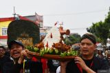 Petugas membawa sesaji untuk dilarung di Sungai Madiun, Kota Madiun, Jawa Timur, Jumat (2/8/2024). Larung sesaji yang dilakukan warga di kawasan sekitar sungai tersebut merupakan tradisi setiap tahun sekali dalam rangkaian kegiatan bersih desa. Antara Jatim/Siswowidodo/mas.