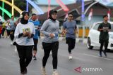 Peserta berlari melintasi jembatan Pante Pirak yang dihiasi bendera merah putih saat mengukuti Fun Run 5 Km Merdeka di Banda Aceh, Aceh, Minggu (4/8/2024). Lomba lari kategori 5 km  yang diikuti 1.050 peserta dari bebagai kalangan  itu dalam rangka menyambut HUT ke 79 Kemerdekaan RI dan dalam rangka menyonsong serta menyemarakan PON XXI Aceh-Sumut 2024. ANTARA FOTO/Ampelsa.