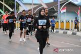 Peserta berlari melintasi jembatan Pante Pirak yang dihiasi bendera merah putih saat mengukuti Fun Run 5 Km Merdeka di Banda Aceh, Aceh, Minggu (4/8/2024). Lomba lari kategori 5 km  yang diikuti 1.050 peserta dari bebagai kalangan  itu dalam rangka menyambut HUT ke 79 Kemerdekaan RI dan dalam rangka menyonsong serta menyemarakan PON XXI Aceh-Sumut 2024. ANTARA FOTO/Ampelsa