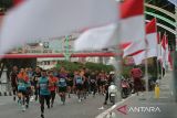 Peserta berlari melintasi jembatan Pante Pirak yang dihiasi bendera merah putih saat mengukuti Fun Run 5 Km Merdeka di Banda Aceh, Aceh, Minggu (4/8/2024). Lomba lari kategori 5 km  yang diikuti 1.050 peserta dari bebagai kalangan  itu dalam rangka menyambut HUT ke 79 Kemerdekaan RI dan dalam rangka menyonsong serta menyemarakan PON XXI Aceh-Sumut 2024. ANTARA FOTO/Ampelsa