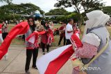 Komunitas pecinta hewan, Indonesia Cat Association (ICA) dan Cat Lovers menggendong kucing  dengan mengenakan kostum  bernuansa merah putih saat pembagian bendera di depan Monumen Replika Pesawat RI-001 Seulawah , Lapangan Blang Padang, Banda Aceh, Aceh,  Minggu (4/8/2024). Komunitas pecinta kucing, ICA dan Cat Lover  di daerah itu membagikan sebanyak 500 lembar bendera merah putih berbagai ukuran kepada pengunjung dalam rangka menyamabut HUT  ke 79  Kemerdekaan Republik Indonesia. ANTARA FOTO/Ampelsa.