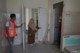 Plt Direktur Rumah Sakit Umum Daerah (RSUD) Aceh Besar dr Susi Mahdalena (tengah) berbincang dengan pekerja saat proses renovasi kamar rawat inap khusus atlet yang cidera saat Pekan Olahraga Nasional (PON) XXI Aceh-Sumut di Indrapuri, Aceh Besar, Aceh, Senin (5/8/2024). Rumah sakit umum tersebut menyiapkan ruang perawatan medis khusus atlet dan tim ofisial PON XXI yang cidera, mulai dari layanan ruang IGD, ruang tindakan darurat, dan ruang rawat inap, dengan kapasitas 17 tempat tidur serta berbagai fasilitas penunjang lainnya, dan sementara dilakukan renovasi skala kecil guna memberi kenyamanan bagi pasien saat PON XXI pada 8-20 September 2024. ANTARA FOTO/Khalis Surry