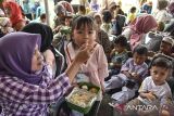 Orang tua menyuapi makanan begizi kepada anak saat percepatan penurunan stunting dan pengendalian inflasi di Desa Gunungsari, Kabupaten Ciamis, Jawa Barat, Selasa (6/8/2024). Tim Percepatan Penurunan Stunting (TPPS) dan Tim Pengendalian Inflasi Daerah (TPID) Ciamis memberikan pelatihan mengolah pangan lokal bergizi seimbang dalam memenuhi gizi anak untuk mencegah stunting pada pertumbuhan anak. ANTARA FOTO/Adeng Bustomi/agr