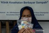 Warga menunjukan obat usai pemeriksaan kesehatan di Klinik Sehat Mitra Enviro Bening Saguling Foundation di Cihampelas, Kabupaten Bandung Barat, Jawa Barat, Rabu (7/8/2024).  Yayasan Bening Saguling Foundation bersama PT Namasindo Plas memberikan pelayanan kesehatan dengan membayar menggunakan sampah minimal satu kilogram bagi warga sekitar yang kurang mampu pada tiap hari rabu dan jumat sebagai aksi nyata dalam menjaga lingkungan dan kesehatan. ANTARA FOTO/Novrian Arbi/agr