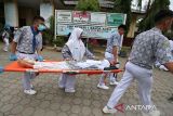 Petugas Unit Kesehatan Sekolah (UKS) menggunakan tandu membawa temannya yang mengalami cidera menjju lokasi evakuasi saat berlangsung tsunami drill di SMP 1 Banda Aceh, Aceh, Rabu (7/8/2024). Tsunami drill yang digelar secara mandiri melibatkan sebanyak 900 murid dan guru di sekolah tersebut bertujuan meningkatkan kesiapsiagaan sekolah, kewaspadaan dan pengurangan resiko bencana. ANTARA FOTO/Ampelsa.