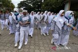 Petugas Unit Kesehatan Sekolah (UKS) memamapah temannya yang cidera berjalan menuju lokasi evakuasi saat berlangsung tsunami drill di SMP 1 Banda Aceh, Aceh, Rabu (7/8/2024). Tsunami drill yang digelar secara mandiri melibatkan sebanyak 900 murid dan guru di sekolah tersebut bertujuan meningkatkan kesiapsiagaan sekolah, kewaspadaan dan pengurangan resiko bencana. ANTARA FOTO/Ampelsa.