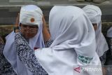 Petugas Unit Kesehatan Sekolah (UKS) memengobati temannya yang mengalami luka pada bagian kepala  saat berlangsung tsunami drill di SMP 1 Banda Aceh, Aceh, Rabu (7/8/2024). Tsunami drill yang digelar secara mandiri melibatkan sebanyak 900 murid dan guru di sekolah tersebut bertujuan meningkatkan kesiapsiagaan sekolah, kewaspadaan dan pengurangan resiko bencana. ANTARA FOTO/Ampelsa.