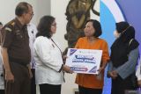 Pj. Wali Kota Kediri Zanariah (kedua kiri) secara simbolis menyerahkan Bantuan Modal Usaha (Banmod) 2024 kepada warga di Kota Kediri, Jawa Timur, Rabu (7/8/2024). Pemerintah daerah setempat menyerahkan Banmod 2024 dari Dana Bagi Hasil Cukai Hasil Tembakau (DBHCHT) kepada 5.617 penerima manfaat masing-masing sebesar Rp2,5 juta. Antara Jatim/Prasetia Fauzani/um
