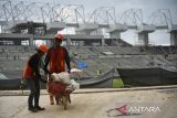 Pekerja menyelesaikan proyek pembangunan Stadion Utama Sumatera Utara yang akan digunakan untuk Pekan Olahraga Nasional (PON) XXI Aceh-Sumut di Batang Kuis, Deli Serdang, Sumatera Utara, Rabu (7/8/2024). Progres pembangunan Stadion Utama Sumut yang akan digunakan untuk penutupan PON XXI Aceh-Sumut 2024 tersebut telah mencapaii 81 persen dan ditargetkan rampung pada akhir Agustus 2024 mendatang. ANTARA FOTO/Fransisco Carolio