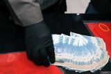 Polisi menata barang bukti uang palsu saat rilis kasus sindikat peredaran uang palsu di Gedung Patriatama Polres Blitar Kota, Jawa Timur, Kamis (8/8/2024). Selain mengamankan tersangka berinisla IP yang diduga merupakan jaringan pengedar uang palsu lintas kota, Satreskrim Polres Blitar Kota juga berhasil mengamankan 130 lembar uang palsu pecahan 50ribu dan jutaan uang asli yang diduga hasil kejahatan pelaku yang kini jaringannya tengah diburu polisi. ANTARA Jatim/Irfan Anshori/mas.