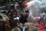 Seorang pengunjuk rasa berusaha mendobrak barikade polisi saat latihan sistem pengamanan kota (Sispamkota) di depan Kantor Komisi Pemilihan Umum (KPU) Kota Surabaya, Surabaya, Jawa Timur, Kamis (8/8/2024). LatihanÂ  itu melibatkan 420 anggota Polri bertujuan untuk memantapkan kesiapan personel Polri dalam mengamankan proses Pemilihan Kepala Daerah (Pilkada) 2024. ANTARA Jatim/Didik Suhartono/mas.
