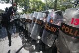 Seorang pengunjuk rasa berusaha mendobrak barikade polisi saat latihan sistem pengamanan kota (Sispamkota) di depan Kantor Komisi Pemilihan Umum (KPU) Kota Surabaya, Surabaya, Jawa Timur, Kamis (8/8/2024). LatihanÂ  itu melibatkan 420 anggota Polri bertujuan untuk memantapkan kesiapan personel Polri dalam mengamankan proses Pemilihan Kepala Daerah (Pilkada) 2024. ANTARA Jatim/Didik Suhartono/mas.