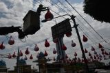 Petugas Dinas Perumahan Rakyat dan Kawasan Permukiman (Perkim) memasang lampion berwarna merah putih di Kota Madiun, Jawa Timur, Kamis (8/8/2024). Pemasangan lampion tersebut untuk menyemarakkan peringatan HUT ke-79 Proklamasi Kemerdekaan RI. Antara Jatim/Siswowidodo/mas.