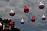 Petugas Dinas Perumahan Rakyat dan Kawasan Permukiman (Perkim) memasang lampion berwarna merah putih di Kota Madiun, Jawa Timur, Kamis (8/8/2024). Pemasangan lampion tersebut untuk menyemarakkan peringatan HUT ke-79 Proklamasi Kemerdekaan RI. Antara Jatim/Siswowidodo/mas.