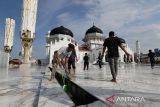 Sejumlah Satuan Kerja Perangkat Aceh (SKPA) bersama warga membersihkan saluran pembuangan air saat  aksi Jumat Bersih di objek wisata religi Masjid Raya Baiturrahman Banda Aceh, Aceh, Jumat (9/8/2024). Pemerintah Aceh mengerahkan seluruh  SKPA dan masyarakat  di daerah itu melaksanakan gotong royong serentak setiap Jumat untuk membersihkan lingkungan kota dan penataan sejumlah objek wisata dalam rangka semarak PON XXI Aceh-Sumut. ANTARA FOTO/Ampelsa.