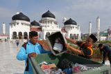 Sejumlah Satuan Kerja Perangkat Aceh (SKPA) bersama warga mengumpulkan sampah aksi Jumat Bersih di objek wisata religi Masjid Raya Baiturrahman Banda Aceh, Aceh, Jumat (9/8/2024). Pemerintah Aceh mengerahkan seluruh  SKPA dan masyarakat  di daerah itu melaksanakan gotong royong serentak setiap Jumat untuk membersihkan lingkungan kota dan penataan sejumlah objek wisata dalam rangka semarak PON XXI Aceh-Sumut. ANTARA FOTO/Ampelsa.