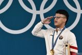 Lifter Indonesia Rizki Juniansyah melakukan hormat saat upacara pengibaran bendera juara kelas 73 kg putra Olimpiade Paris 2024 di South Paris Arena, Paris, Prancis, Kamis (8/8/2024). Rizki meraih medali emas setelah berhasil meraih total angkatan 354 kilogram sehingga menduduki peringkat pertama dari 12 lifter yang turut serta dalam nomor tersebut. ANTARA FOTO/Wahyu Putro A/wsj.