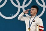 Lifter Indonesia Rizki Juniansyah melakukan hormat saat upacara pengibaran bendera juara kelas 73 kg putra Olimpiade Paris 2024 di South Paris Arena, Paris, Prancis, Kamis (8/8/2024). Rizki meraih medali emas setelah berhasil meraih total angkatan 354 kilogram sehingga menduduki peringkat pertama dari 12 lifter yang turut serta dalam nomor tersebut. ANTARA FOTO/Wahyu Putro A/app/wpa.