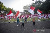 Anak - anak mengibarkan bendera Merah Putih di halaman Gedung Museum Perundingan Linggarjati, Kuningan, Jawa Barat, Jumat (9/8/2024). Pemasangan 10.001 bendera Merah Putih tersebut dalam rangka menyambut perayaan HUT ke-79 Kemerdekaan RI. ANTARA FOTO/Dedhez Anggara/agr