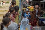 Seniman dari kelompok teater Bon Puppet berinteraksi dengan anak-anak saat menampilkan teatrikal boneka bertajuk Taman Dorong di Braga, Bandung, Jawa Barat, Sabtu (10/8/2024). Teater tersebut ditampilkan dengan merespon ruang publik dan berkeliling dalam permukiman bersama anak-anak di Kawasan Braga agar tetap bisa berimajinasi, bertualang, bermain hingga peduli akan kondisi lingkungan perkampungan yang menjadi tempat tinggal dan berkehidupan. ANTARA FOTO/Novrian Arbi/agr