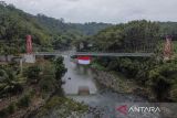 Warga membentangkan bendera Merah Putih di jembatan gantung Sukamenak, Kampung Benteng, Kecamatan Purbaratu, Kota Tasikmalaya, Jawa Barat, Minggu (11/8/2024). Pembentangan bendera Merah Putih berukuran 60 meter persegi tersebut dalam rangka persiapan upacara menyambut HUT Ke-79 RI. ANTARA FOTO/Adeng Bustomi/agr