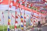 Pengendara melintasi jalan Galumpit yang dihias dengan bendera Merah Putih di Cileunyi, Kabupaten Bandung, Jawa Barat, Senin (12/8/2024). Warga mendekorasi jalan tersebut dengan ornamen bernuansa Merah Putih guna menyambut HUT Ke-79 Republik Indonesia. ANTARA FOTO/Novrian Arbi/agr