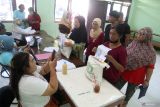 Petugas mendokumentasikan warga penerima manfaat saat pengambilan bantuan pangan cadangan beras di Balai Kelurahan Bangsal, Kota Kediri, Jawa Timur, Rabu (14/8/2024). Pemerintah daerah setempat bersinergi dengan Perum Bulog menyalurkan bantuan 336.320 kilogram beras periode bulan Agustus 2024 untuk 33.632 keluarga penerima manfaat. ANTARA Jatim/Prasetia Fauzani/mas.