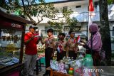 Siswa SDN Patrakomala memberikan bendera merah putih kepada pedagang di Jalan Menado, Bandung, Jawa Barat, Rabu (14/8/2024). SDN Patrakomala membagikan 350 bendera secara gratis kepada pengendara dalam rangka memperingati HUT Ke-63 Pramuka tahun 2024. ANTARA FOTO/Raisan Al Farisi/agr