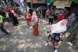 Pedagang mengikuti lomba mengeluarkan bola dalam kardus di kawasan Pasar Larangan, Sidoarjo, Kamis (15/8/2024). Perlombaan yang diikuti para pedagang pasar tradisional tersebut digelar untuk memeriahkan HUT ke-79 Republik Indonesia sekaligus meningkatkan kerukunan dan kekompakan antarwarga. Antara Jatim/Umarul Faruq/mas