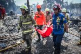 Petugas pemadam kebakaran dan BPBD membawa jenazah korban kebakaran di Penjaringan, Jakarta, Rabu (14/8/2024). Kebakaran tersebut menghanguskan 120 rumah semi permanen dan 35 lapak, serta menyebabkan seorang korban jiwa. ANTARA FOTO/Rivan Awal Lingga/nym.