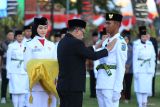 Pj Gubernur Jawa Timur Adhy Karyono (tengah) menyematkan pin kepada salah satu perwakilan anggota pasukan pengibar bendera pusaka saat upacara pegukuhan di Gedung Negara Grahadi, Surabaya, Jumat (16/8/2024). Sebanyak 64 pelajar terpilih dari berbagai daerah di Jawa Timur dikukuhkan untuk melaksanakan upacara pengibaran dan penurunan Bendera Merah Putih pada peringatan HUT ke-79 Kemerdekaan Republik Indnesia di Provinsi Jawa Timur. ANTARA Jatim/Moch Asim/um.