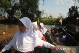 Sejumlah siswi SDN Basirih 10 bersiap untuk mengikuti lomba balap perahu yang diisi tiga orang dengan jarak sekitar 15 meter, kemudian peserta berputar menuju garis finis di Sungai Jelai (Anak Sungai Martapura) Kelurahan Basirih Selatan, Kota Banjarmasin, Kalimantan Selatan, Sabtu (17/8/2024). Lomba balap perahu kecil yang diikuti 44 siswa SDN Basirih 10 tersebut dalam rangka memeriahkan HUT ke-79 Republik Indonesia. ANTARA/Abdul Hakim.