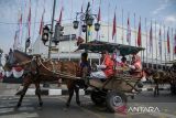 Warga menaiki delman saat mengikuti karnaval delman kemerdekaan di Bandung, Jawa Barat, Sabtu (17/8/2024). Karnaval tersebut untuk menyemarakkan HUT Ke-79 Republik Indonesia. ANTARA FOTO/Novrian Arbi/agr