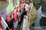 Warga menampilkan tarian bendera Merah Putih saat berkeliling di permukiman kawasan Bongkeng Art Space, Bandung, Jawa Barat, Sabtu (17/8/2024). Gelaran tarian tersebut merupakan rangkaian 17 jam menari kemerdekaan dalam memeriahkan peringatan HUT ke-79 Republik Indonesia. ANTARA FOTO/Novrian Arbi/agr
