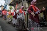 Warga menampilkan tarian bendera Merah Putih saat berkeliling di permukiman kawasan Bongkeng Art Space, Bandung, Jawa Barat, Sabtu (17/8/2024). Gelaran tarian tersebut merupakan rangkaian 17 jam menari kemerdekaan dalam memeriahkan peringatan HUT ke-79 Republik Indonesia. ANTARA FOTO/Novrian Arbi/agr
