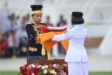 Presiden Joko Widodo (kiri) menyerahkan duplikat Bendera Pusaka kepada anggota Paskibraka 2024 asal Kalimantan Timur Livenia Evelyn Kurniawan (kanan) untuk dikibarkan dalam upacara Peringatan Detik-detik Proklamasi Kemerdekaan Republik Indonesia (RI) di lapangan upacara Istana Negara Ibu Kota Nusantara (IKN), Penajam Paser Utara, Kalimantan Timur, Sabtu (17/8/2024). Upacara dalam rangka hari ulang tahun (HUT) ke-79 RI tersebut mengusung tema Nusantara Baru Indonesia Maju. ANTARA FOTO/Hafidz Mubarak A/app/wpa. 