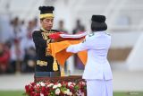 Presiden Joko Widodo (kiri) menyerahkan duplikat Bendera Pusaka Merah Putih kepada anggota Paskibraka 2024 asal Kalimantan Timur Livenia Evelyn Kurniawan (kanan) untuk dikibarkan dalam upacara Peringatan Detik-detik Proklamasi Kemerdekaan Republik Indonesia (RI) di lapangan upacara Istana Negara Ibu Kota Nusantara (IKN), Penajam Paser Utara, Kalimantan Timur, Sabtu (17/8/2024). Upacara dalam rangka hari ulang tahun (HUT) ke-79 RI tersebut mengusung tema Nusantara Baru Indonesia Maju. ANTARA FOTO/Hafidz Mubarak A/wsj.