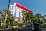 Pengendara melintas di depan bendera Merah Putih raksasa yang membentang di depan gedung Pemkab Bojonegoro, Jawa Timur, Sabtu (17/8/2024). Pembentangan bendera berukuran 17 x 45 meter yang dilakukan Pemerintah setempat tersebut untuk memperingati hari ulang tahun (HUT) ke-79 Republik Indonesia. ANTARA Jatim/Muhammad Mada/mas.