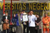 Rektor Universitas Negeri Surabaya (Unesa) Nurhasan (ketiga kiti) menerima piagam MURI dari  Direktur Operasional Museum Rekor Dunia Indonesia (MURI) Yusuf Ngadri (ketiga kanan) usai upacara peringatan Hari Ulang Tahun (HUT) ke-79 Republik Indonesia di Surabaya, Jawa Timur, Sabtu (17/8/2024). Unesa memecahkan dua rekor Museum Rekor Dunia Indonesia (MURI) yaitu perguruan tinggi yang membuat poster terbanyak berbasis kecerdasan buatan dan teknologi informasi lainnya, sebanyak 632 poster yang melibatkan mahasiswa serta rekor sebagai perguruan tinggi dengan mitra usaha mikro, kecil dan menengah (UMKM) bersertifikat produk halal terbanyak dengan total 160. ANTARA Jatim/Moch Asim/um.