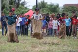 Sejumlah anak beradu cepat saat lomba balap karung di Desa Lamgapang, Krueng Barona Jaya, Aceh Besar, Aceh Minggu (18/8/2024). Perlombaan rakyat seperti balap karung, parut kelapa, estafet tepung terigu tersebut diikuti warga lintas usia, yang digelar untuk memeriahkan HUT ke 79 Kemerdekaan Republik Indonesia, sekaligus upaya dalam meningkatkan kekompakan antar sesama masyarakat. ANTARA FOTO/Khalis Surry