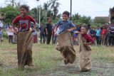 Sejumlah anak beradu cepat saat lomba balap karung di Desa Lamgapang, Krueng Barona Jaya, Aceh Besar, Aceh Minggu (18/8/2024). Perlombaan rakyat seperti balap karung, parut kelapa, estafet tepung terigu tersebut diikuti warga lintas usia, yang digelar untuk memeriahkan HUT ke 79 Kemerdekaan Republik Indonesia, sekaligus upaya dalam meningkatkan kekompakan antar sesama masyarakat. ANTARA FOTO/Khalis Surry