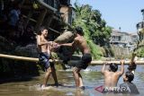 Warga bertanding lomba kerakyatan gebuk bantal di aliran sungai Cikapundung, Bandung, Jawa Barat, Minggu (18/8/2024). Warga kawasan bantaran sungai tersebut memanfaatkan aliran sungai dangkal untuk melaksanakan lomba dalam rangka memeriahkan peringatan HUT Ke-79 Republik Indonesia. ANTARA FOTO/Novrian Arbi/agr