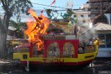 Replika kapal naga yang berisi berbagai persembahan dibakar saat ritual sembahyang rebutan di Tempat Ibadah Tri Dharma (TITD) Hong San Ko Tee, Surabaya, Jawa Timur, Minggu (18/8/2024). Sembahyang rebutan itu dilakukan setahun sekali pada tanggal 15 bulan tujuh Imlek dengan membakar berbagai bentuk replika di antaranya rumah, mobil, baju dan lain sebagainya sebagai persembahan untuk arwah leluhur. Antara Jatim/Didik Suhartono/um