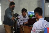 Petugas Dinas Kependudukan dan Catatan Sipil Kota Pontianak memegang kain biru latar belakang saat perekaman Kartu Tanda Penduduk Penduduk elektronik (e-KTP) untuk pelajar di SMK-SMTI di Pontianak, Kalimantan Barat, Senin (19/8/2024). Dinas Kependudukan dan Catatan Sipil Kota Pontianak melaksanakan jemput bola perekaman data KTP elektronik ke sekolah-sekolah untuk memudahkan pemilih pemula memberikan hak suaranya di Pilkada serentak 2024. ANTARA FOTO/Jessica Wuysang