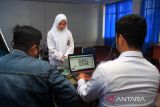 Dua petugas Dinas Kependudukan dan Catatan Sipil Kota Pontianak melakukan perekaman Kartu Tanda Penduduk Penduduk elektronik (e-KTP) untuk pelajar di SMK-SMTI di Pontianak, Kalimantan Barat, Senin (19/8/2024). Dinas Kependudukan dan Catatan Sipil Kota Pontianak melaksanakan jemput bola perekaman data KTP elektronik ke sekolah-sekolah untuk memudahkan pemilih pemula memberikan hak suaranya di Pilkada serentak 2024. ANTARA FOTO/Jessica Wuysang