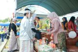 Dua pelajar sekolah dasar berpakaian adat menyerahkan sebuah cinderamata kepada Ketua Tim Penggerak PKK Kotabaru Fatma Idiana saat Karnaval Hari Ulang Tahun (HUT) ke-79 Kemerdekaan Republik Indonesia di Taman Siring Laut Kotabaru, Ahad (18/8/2024).(ANTARA/HO-Pemkab Kotabaru)