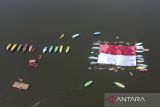 Foto udara petugas dan warga membetangkan bendera Merah Putih raksasa saat upacara bendera di Situ Lengkong, Desa Panjalu, Kabupaten Ciamis, Jawa Barat, Sabtu (17/8/2024). Upacara di atas permukaan danau dengan membentangkan bendera merah putih berukuran 750 meter persegi dan dikelilingi 2024 bendera itu untuk memperingati HUT Ke-79 Kemerdekaan RI. ANTARA FOTO/Adeng Bustomi/agr