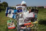 Seorang aktivis lingkungan dari Ecoton membawa sampah plastik impor saat berunjuk rasa di depan Kantor Konsulat Jenderal Australia di Surabaya, Jawa Timur, Senin (19/8/2024). Mereka mendesak penghentian pengiriman sampah plastik dari Australia ke Indonesia. ANTARA FOTO/Didik Suhartono/rwa.