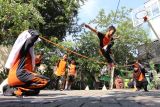 Murid kelas IV SD Negeri Airlangga 3 Surabaya memainkan permainan tradisional lambasena atau lompat tali dari susunan gelang  karet saat sosialisasi dolanan nusantara di Surabaya, Jawa Timur, Rabu (21/8/2024). Kegiatan yang diselenggarakan komunitas kampoeng dolanan tersebut guna melestarikan permainan tradisional yang ada di nusantara.sekaligus menyemarakkan Bulan Permainan Rakyat dan Olahraga Tradisional (BPROT). ANTARA Jatim/Moch Asim/um.